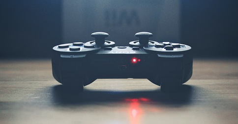 Контроллер PlayStation 3, лежащий на деревянной поверхности Контроллер PlayStation 3, лежащий на деревянной поверхности