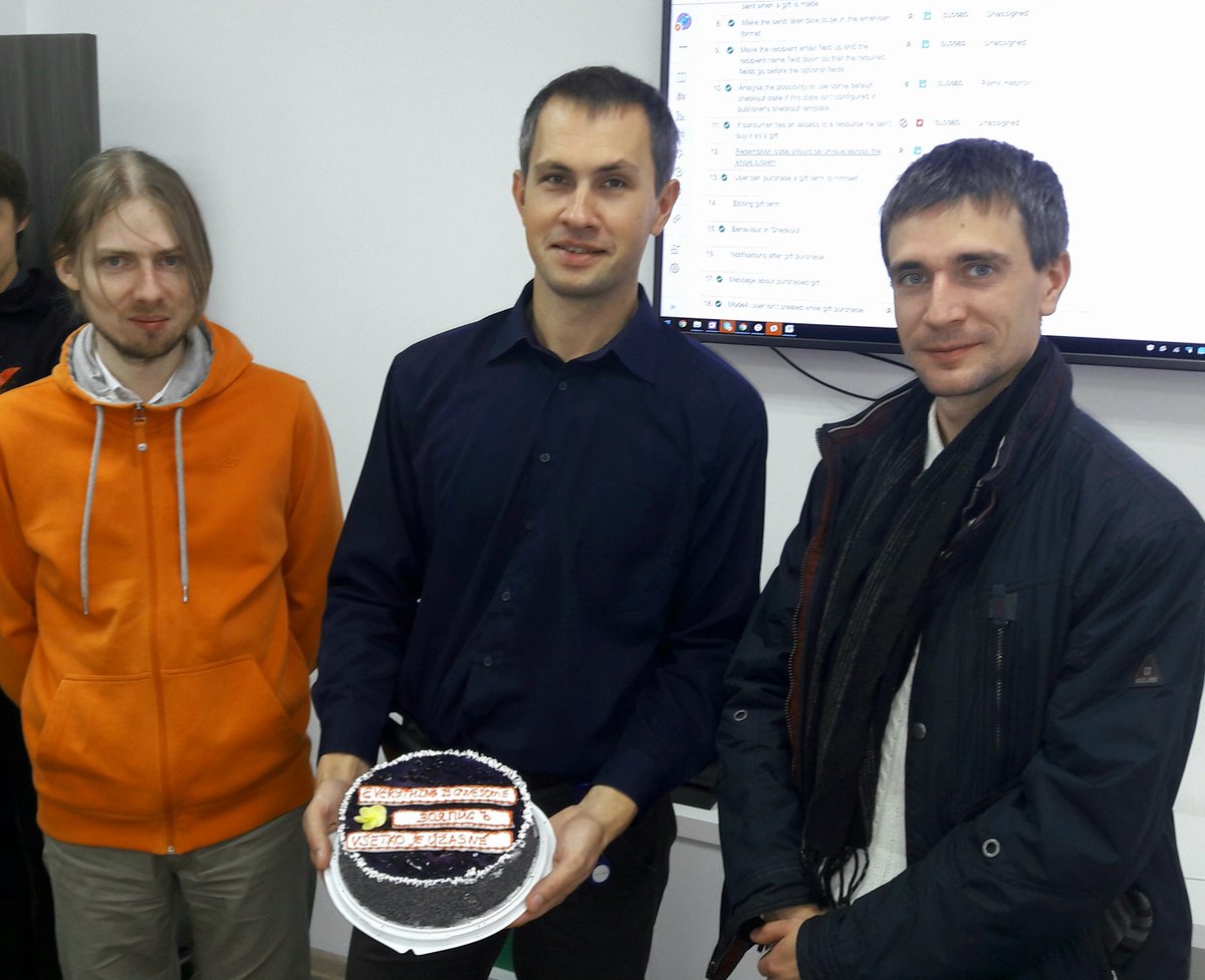 Автор (в оранжевом худи) и его коллеги с тортиком. На тортике написано «всё отлично» на 3 языках