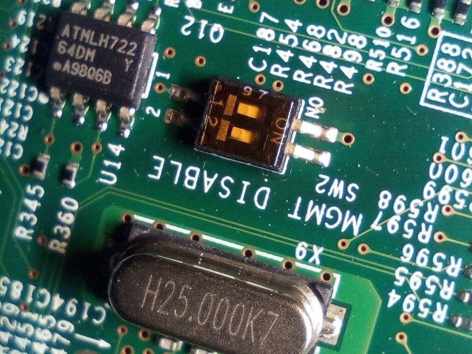 Ниже центра кадра расположен SMT-чип, а в левом верхнему углу— EEPROM