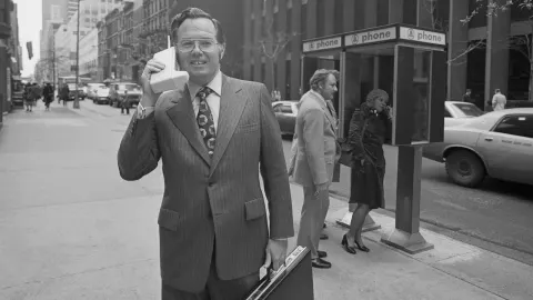 Вице-президент Motorola Джон Ф. Митчелл демонстрирует, насколько легко можно использовать новейший продукт компании — портативную радиотелефонную систему Dyna TAC. Нью-Йорк, штат Нью-Йорк, 3 апреля 1973 года.