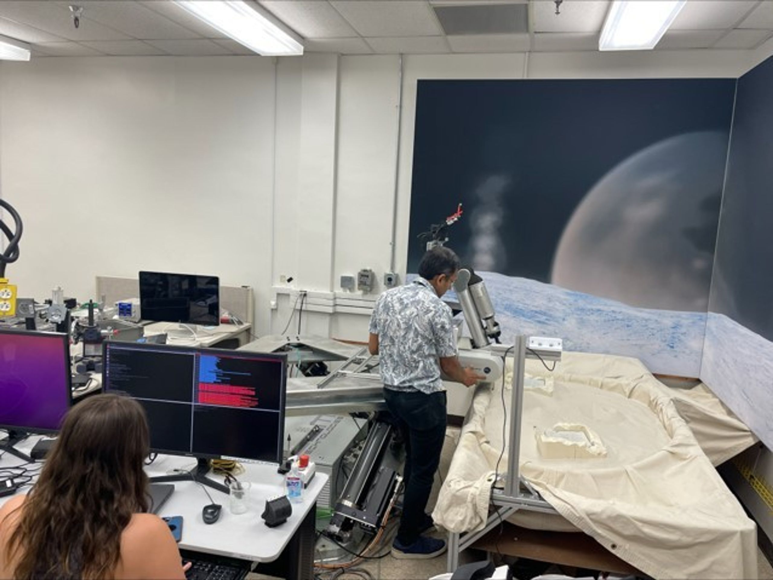  Иллюстрация 5. Эрика Тевере (на станции оператора) и Ашиш Гоэл (на манипуляторе робота) настраивают испытательный стенд OWLAT для использования.