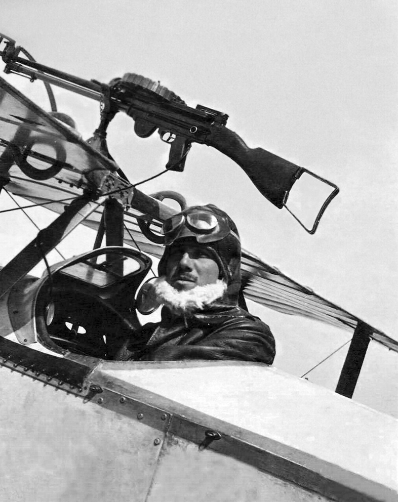 Фиксированная установка пулемёта над верхним крылом биплана. Итальянский лётчик Франческо Баракка в кабине своего Ньюпора-11. Видна тяга, ведущая к спуску оружия.
