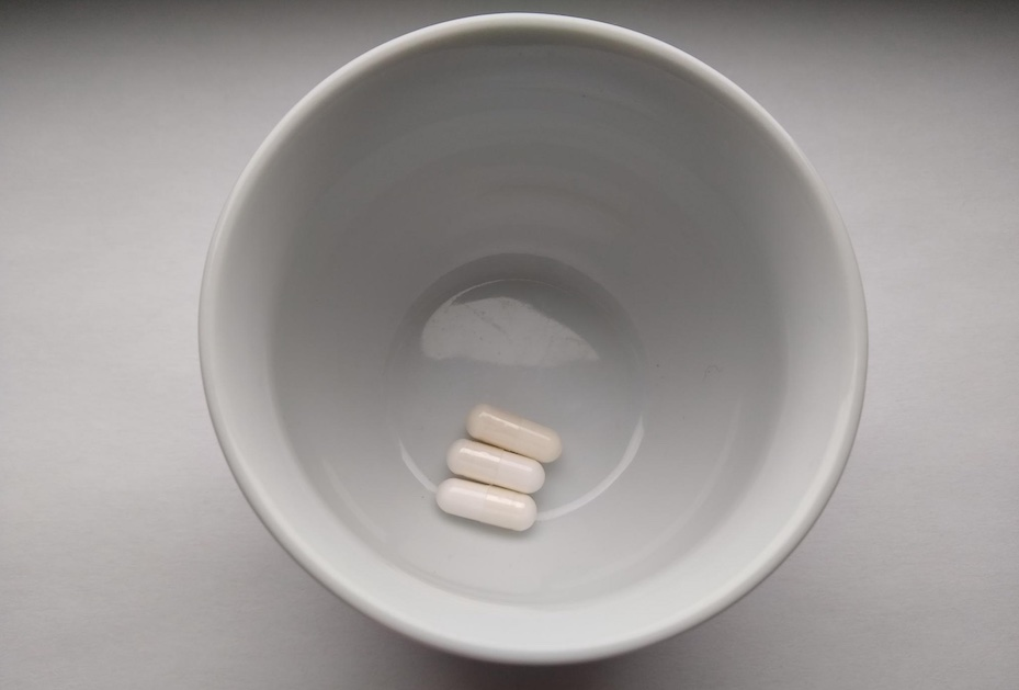 На этой фотографии изображена одна капсула витамина D (сверху) и две капсулы теанина