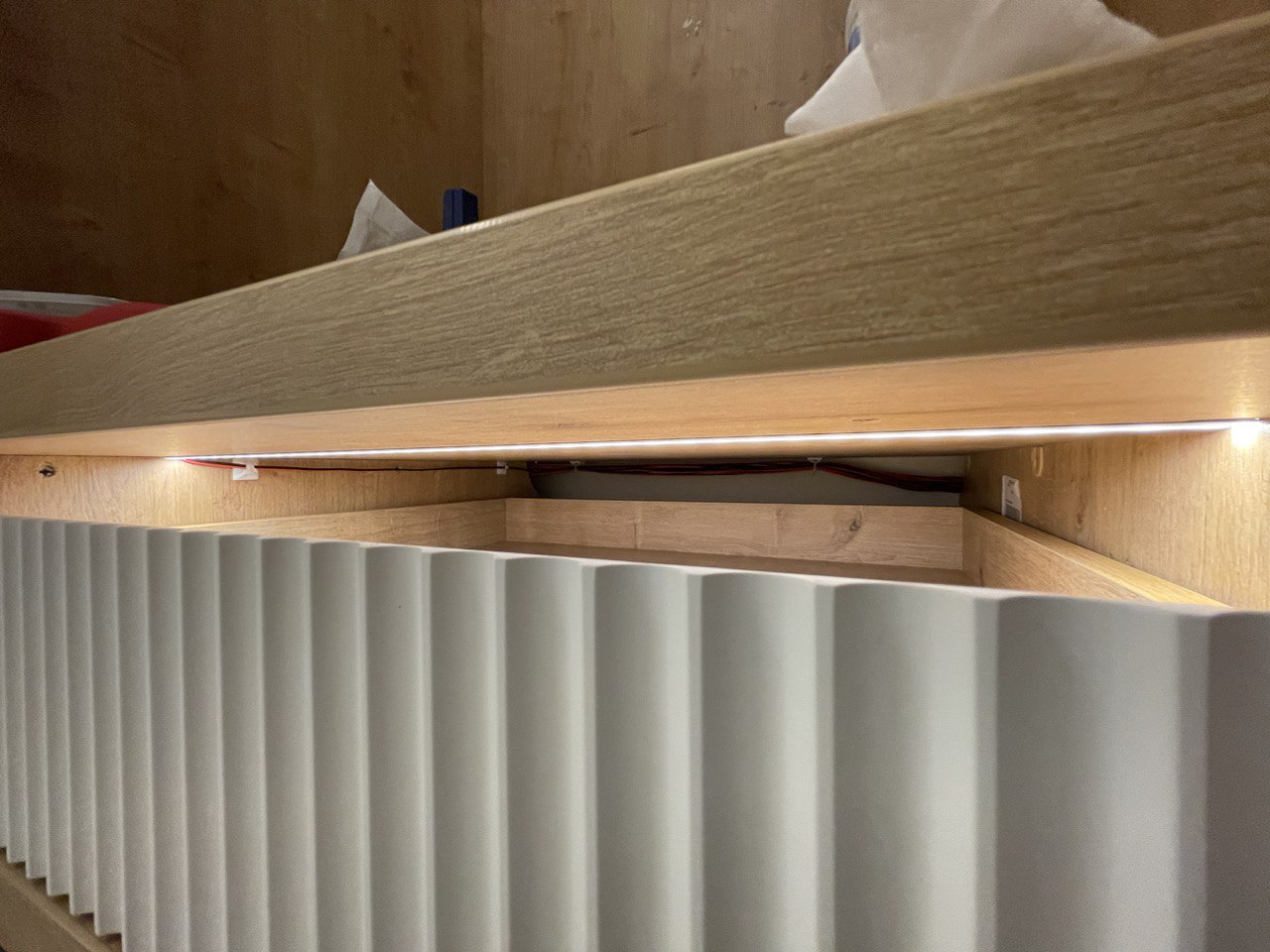 Щель между фасадом ящика и верхней полкой. Так задумал дизайнер. Выполняет роль невидимой ручки и смотрится необычно