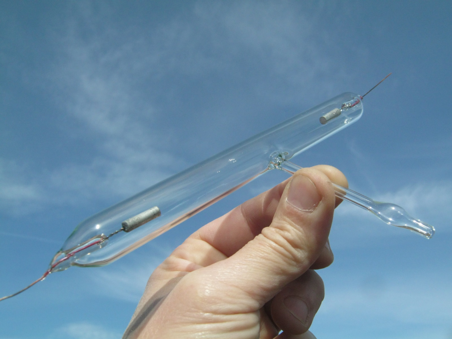 Фото 1.5. Не тонкую алюминиевую проволоку г-н Минье применяет и для электродов разрядной трубки (трубка Гейслера) для грубой индикации степени разрежения в своей низковакуумной системе. Интересен способ соединения алюминия с проволокой другого металла — аналогичный вплавлению платины в медь. На фото: Гейслеровская трубка автора с подобными электродами [1]