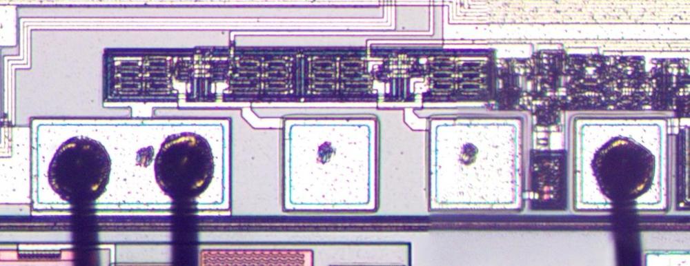 A close-up of the die showing three bond pads with bond wires and two bond pads without bond wires.