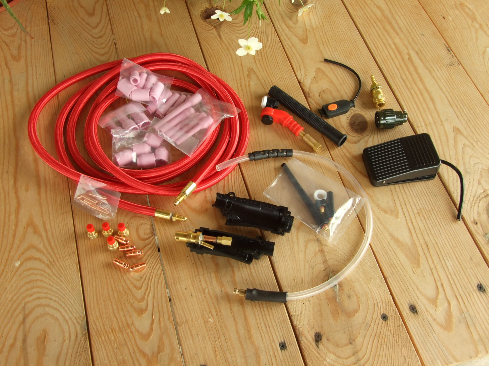 Фото 2.1. Разъёмы силовые, газовые и управляющие у TIG горелок различаются от аппарата к аппарату. Их приходится переделывать, искать переходники или сразу собрать горелку из нужных компонентов. На фото — комплект для сборки маломощной горелки с воздушным охлаждением WP-9. Вариант с поворотной головкой-шарниром и включением педалью. Здесь же набор для неё сопел, цанг, их держателей и газовых линз, для четырёх популярных диаметров электродов