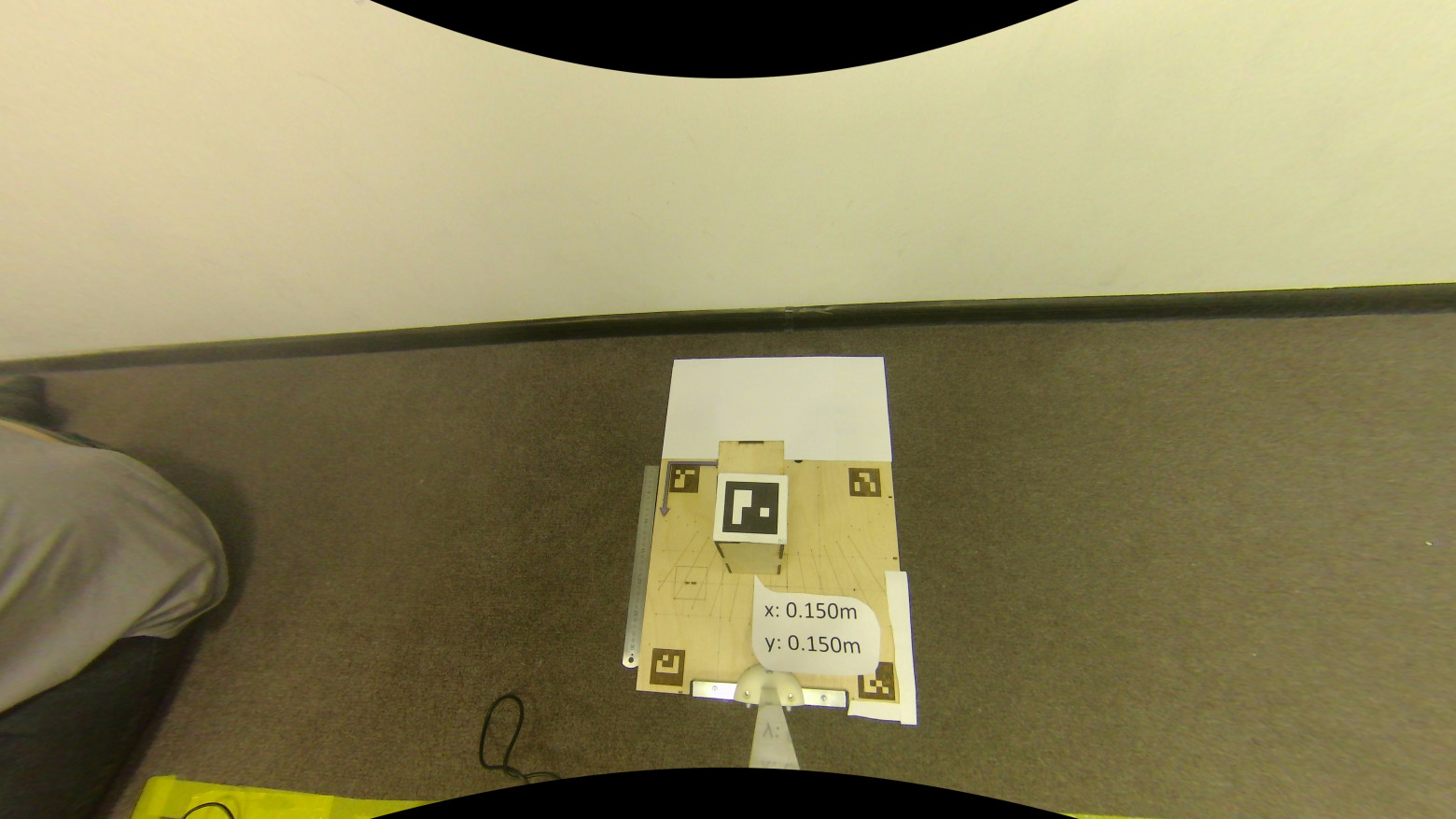 Изображение демонстрационного стенда (фанерная подложка 0.35×0.35м) с удалённым эффектом (undistorted) «рыбий глаз» (fisheye); фанерная подложка с изображёнными ArUco маркерами является объектом (), задающим систему координат в которой рассчитываются пространственные координаты центра ArUco маркера () на фанерной коробке; целевая позиция (0.15; 0.15; -0.208)