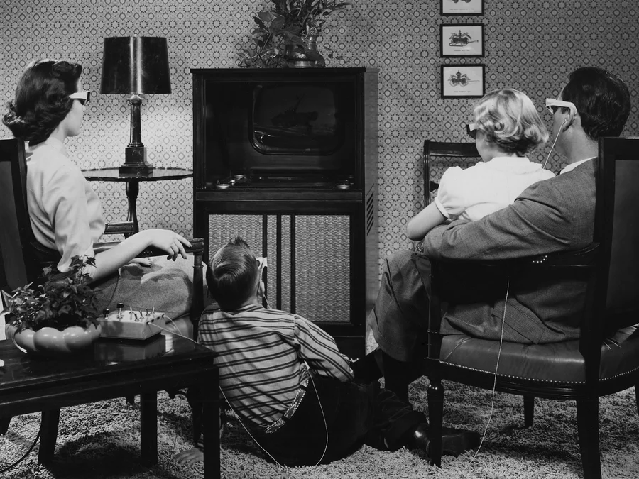 Семья смотрит программы через поляризационные очки