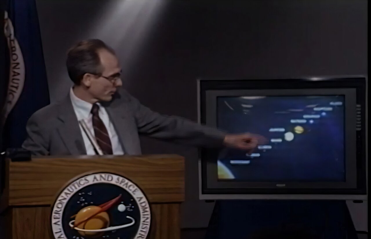 На архивных кадрах исторической пресс-конференции представители миссии NASA демонстрируют исторические снимки шести планет нашей Солнечной системы, включая крошечную точку под названием Земля.  Эд Стоун, научный сотрудник миссии «Вояджер» NASA, выступает соведущим пресс-конференции 6 июня 1990 года, на которой команда миссии представила «Семейный портрет Солнечной системы» — мозаичное изображение шести из восьми планет Солнечной системы, включая Землю. Credit: NASA/JPL-Caltech