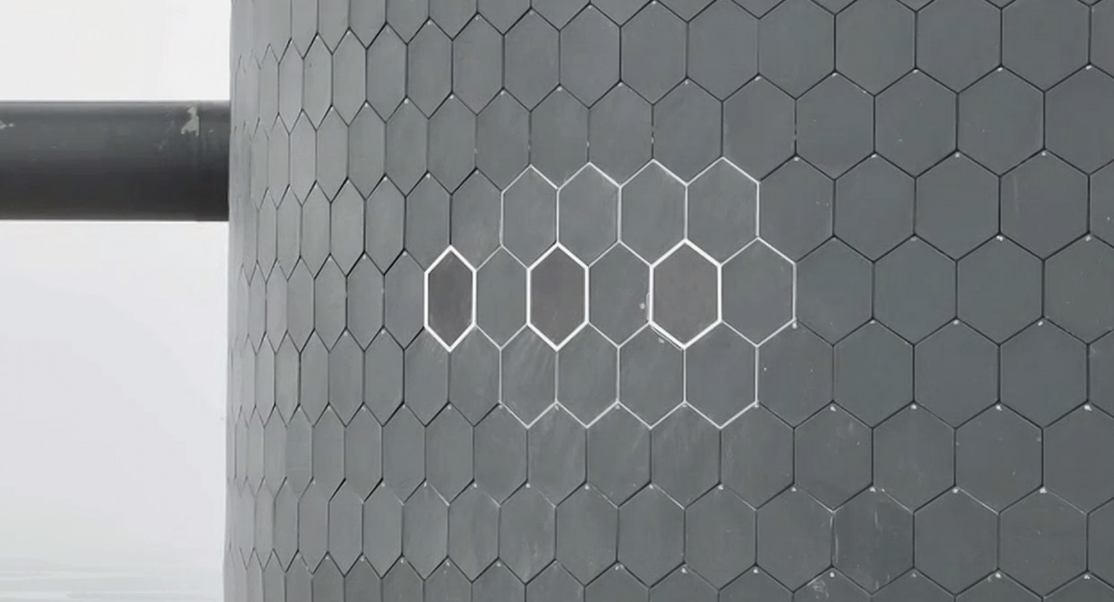 Вид части теплового экрана Starship, включая три экспериментальные металлические плитки. Каждая плитка размером примерно с обеденную тарелку. Фото предоставлено SpaceX  