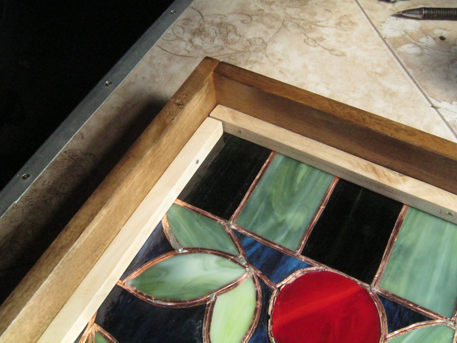 Фото 7.1. Стеклянная работа укладывается в раму изнутри, зазоры заполняются небольшим количеством силиконового нейтрального прозрачного герметика, витраж фиксируется калиброванными деревянными брусочками 