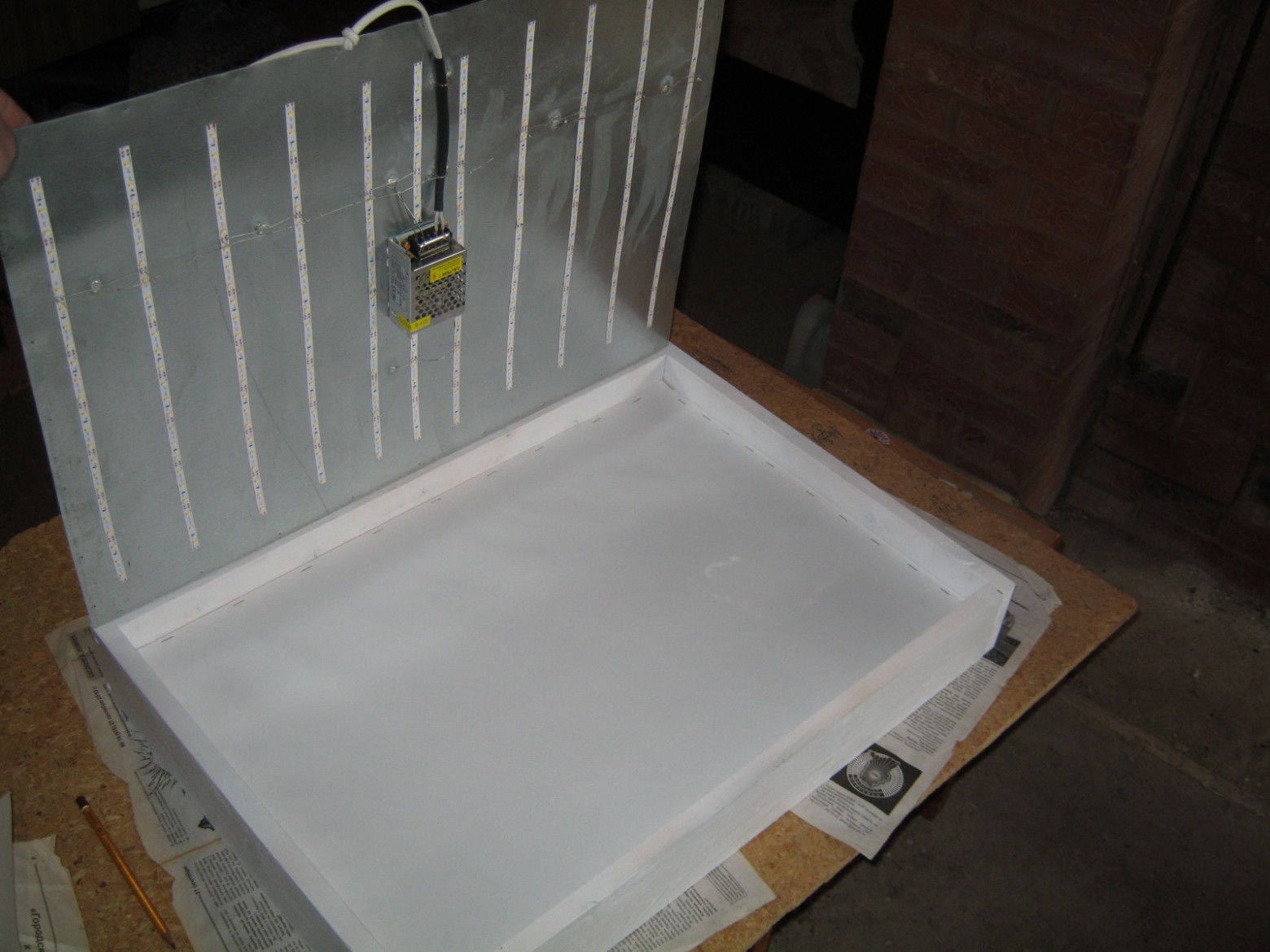 Фото 7.3. Шина лампы припаивается к гибким выводам разъёма на корпусе, проверяется работоспособность, заднюю стенку закрепляем. На фото — вариант светильника с внутренним модулем питания и непрозрачной отделкой — для светлой комнаты с белой мебелью