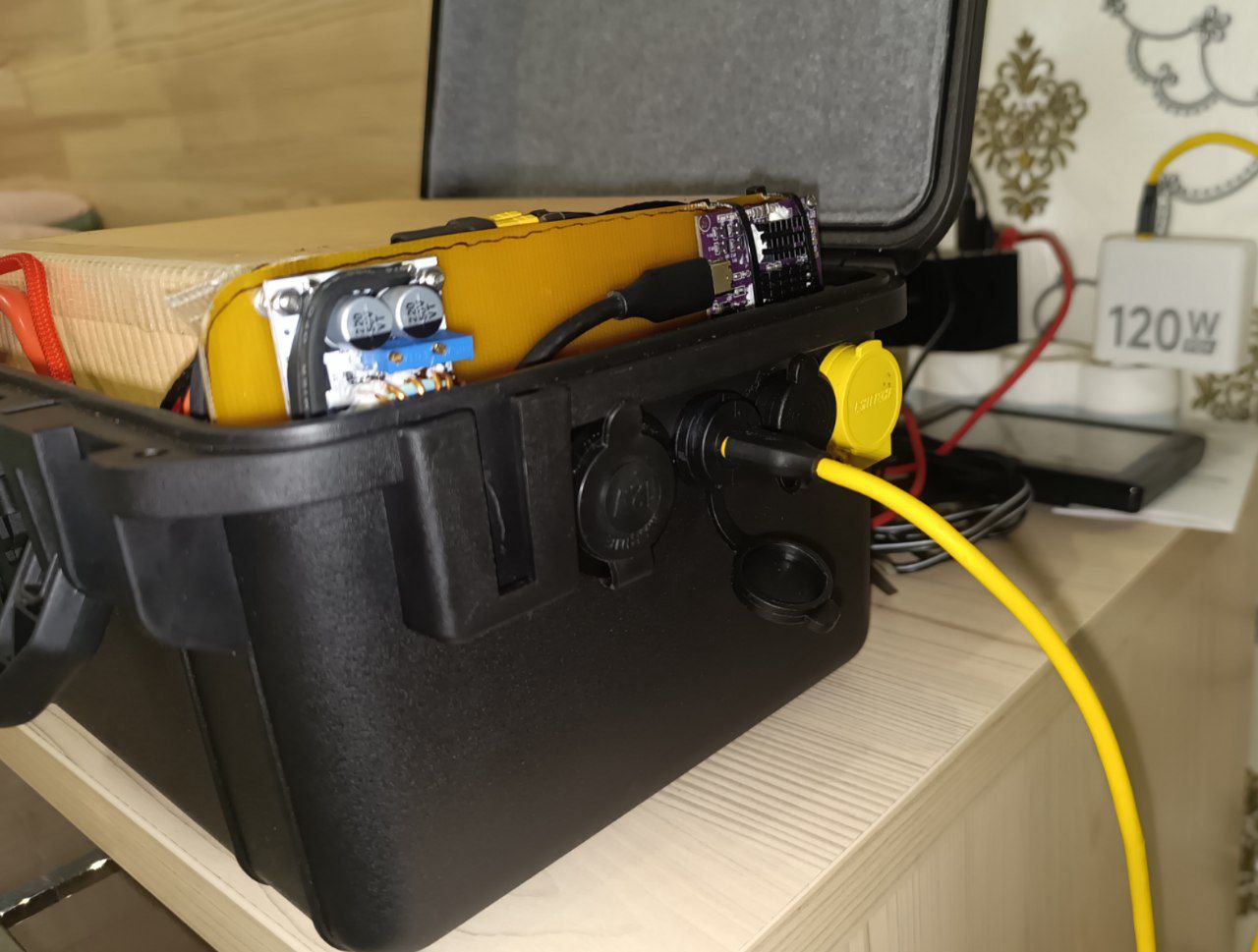 Прямо на прикроватной тумбочке, от телефонной зарядки