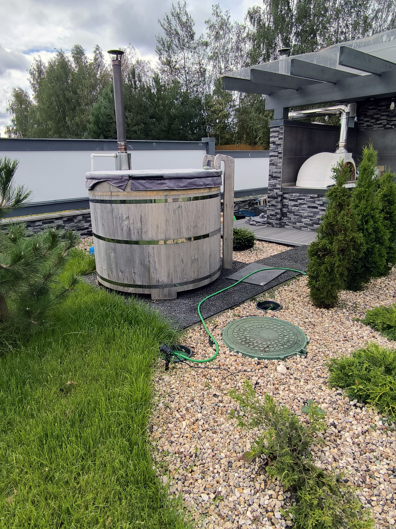 Есть и японская ванна фурако с дровяным нагревом (уже требует шлифовки и покрытия). На переднем плане — люк кессона скважины  