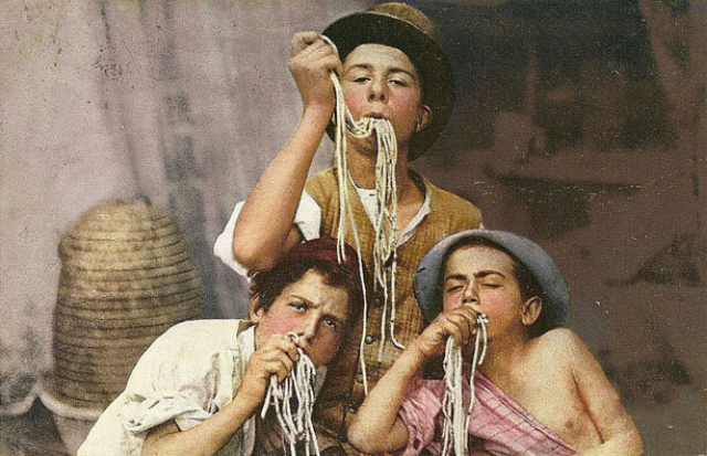 Дети неаполитанской бедноты едят спагетти, начало ХХ века