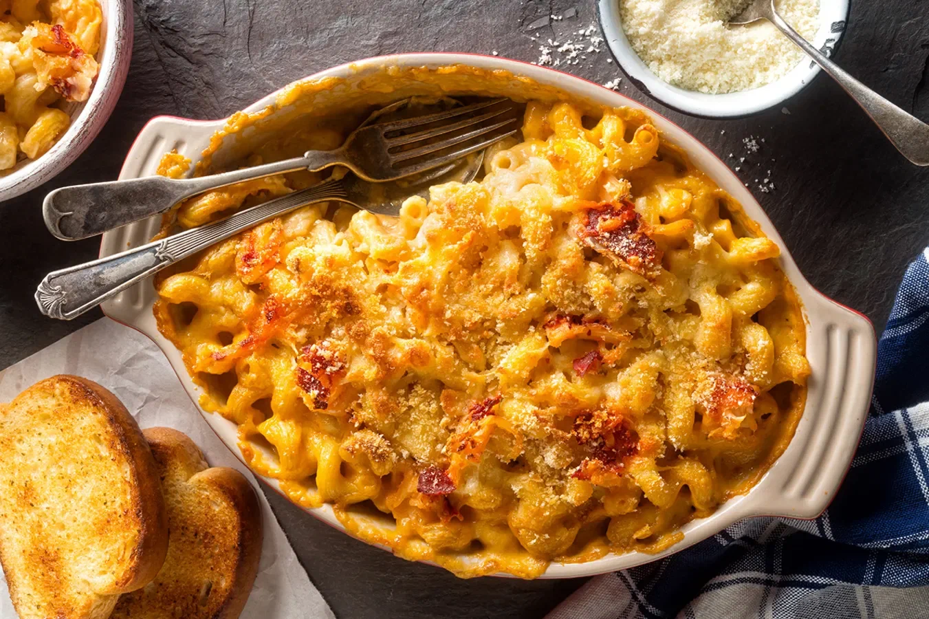 Macaroni & Cheese в американском стиле: похожую на кашу констистенцию даёт соус бешамель, а ярко-жёлтый цвет — сыр чеддер, который традиционно принято подкрашивать до почти оранжевого состояния. Кроме того, американцы нередко доводят блюдо в духовке для образования сырной корочки