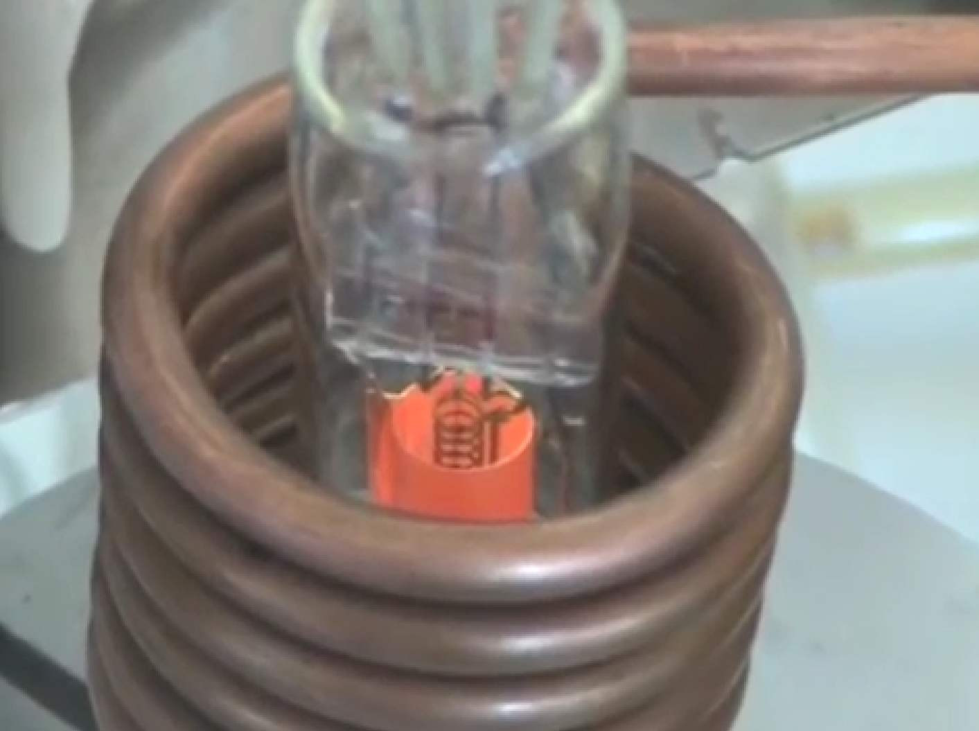 Фото 2.6. Вот как выглядит нагрев ТВЧ от современного лампового ВЧ генератора, при обезгаживании откачиваемой лампы-триода в кустарном производстве [3]. Обратим внимание на тёмную, холодную сетку. В первых лампах иногда её даже делали со вторым технологическим выводом (дополнительное удорожание и усложнение), чтобы, как и катод нагревать пропусканием тока