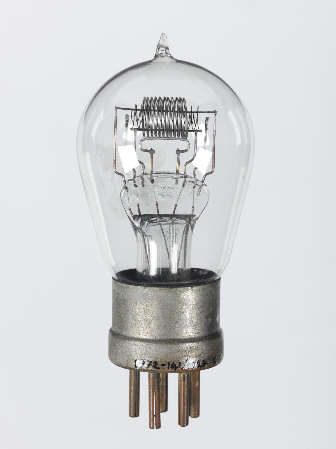 Фото 1.1. Яркий пример электронной лампы с анодом-спиралью — Thorpe K4 британской компании Bower Electric, середины 1924 г. Лампа с прямой вольфрамовой нитью накала — катодом и примечательна двумя сетками. Лампа-тетрод, но в 1920-х «би-гриды» были низкоомными, с малым коэффициентом усиления, а обе сетки служили только для управления — смешивания принимаемого сигнала с сигналом гетеродина в супергетеродинном приёмнике. Обе сетки не отделены экранами и могли работать только на сравнительно невысоких частотах. В целом, электродная система до боли напоминает французский триод ТМ [1], а спиральный анод мог быть введён только для обхода удобной запатентованной конструкции