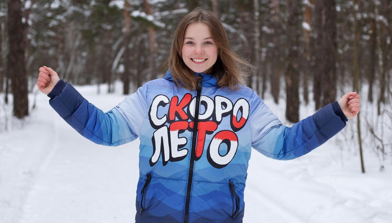 Prompt: Красивая женщина в пуховике на котором написано скоро лето