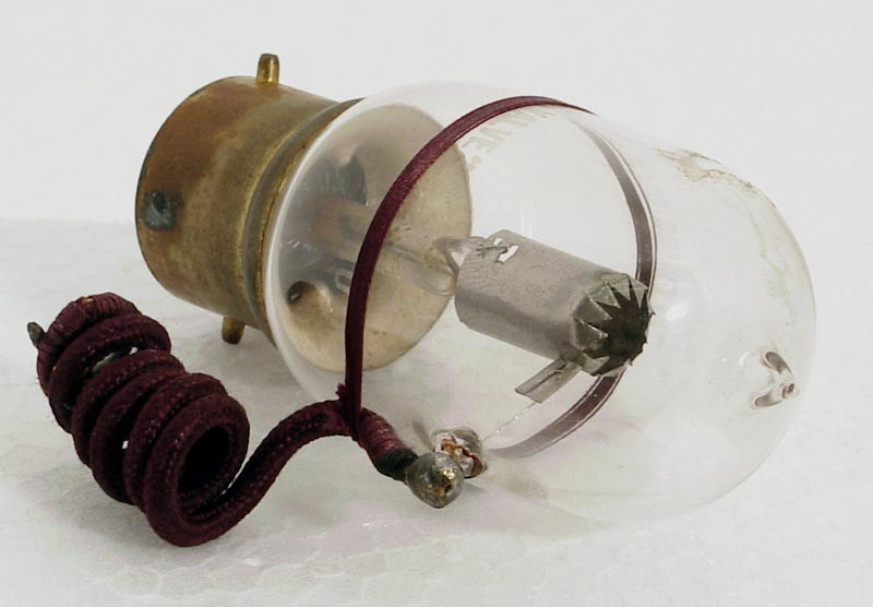 Фото 1.5. Поздний коммерческий клапан Флеминга. Электродная система выполнена куда как культурнее, внешний грубый вывод от нежного впая зафиксирован на колбе ремешком. Цоколь уже удобного байонетного типа. Вольфрамовая нить накала — короткая дуга на V-образных держателях, работающая от батареи 4 вольта, светилась так же ярко, как и обычная осветительная лампа. Клапаны Флеминга были «термоионными» — с невысоким вакуумом и остатками атмосферных газов