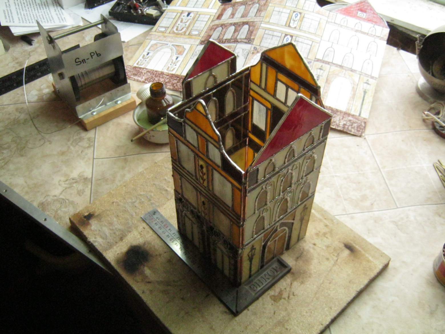 Фото 3.3. Скрепление сторон на живую нитку — несколькими каплями припоя. После наплавления угловых швов, внутри устанавливается несколько проволочных или стеклянных раскосов и поддержек для сильно выступающих (сверху) элементов. Теперь можно снять размеры для изготовления подошвы светильника