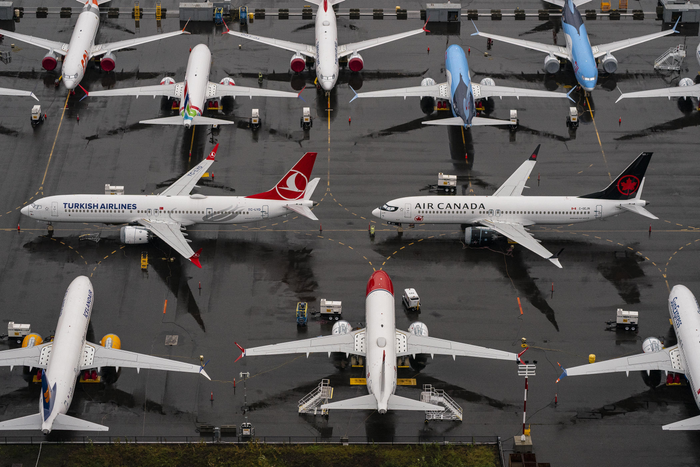Parked airplanes on wet tarmac, featuring Turkish Airlines and Air Canada jets.