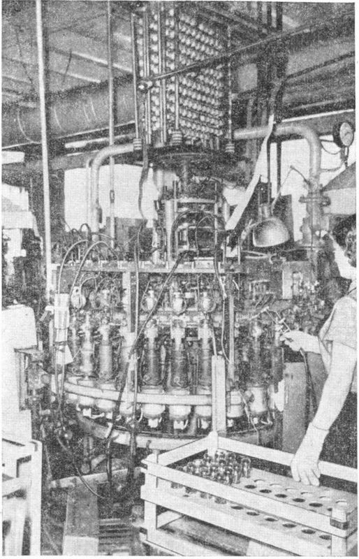 Фото 2.6. Внешний вид откачного полуавтомата-карусели [5]. Оператор — барышня с ручной горелкой отпаивает обработанные лампы. Для 24-позиционного автомата время стоянки карусели на каждой позиции — 8 секунд, а полный цикл откачки — 192 секунды (3 минуты 12 секунд!)