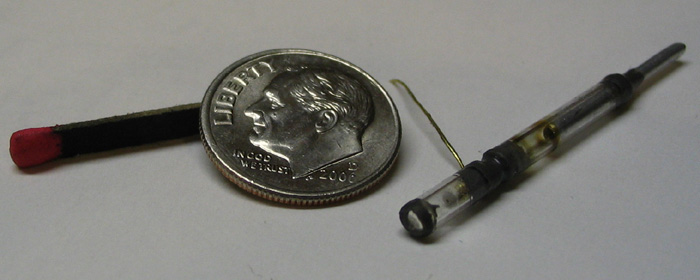 Эту крохотную ЭЛТ я изготовил из стеклянной трубки с внешним диаметром 3 мм, и она свободно входит в отверстие 1/8". Катод, находящийся в «хвосте», сделан из алюминиевой трубки диаметром 1/16", которая также служит для откачки воздуха