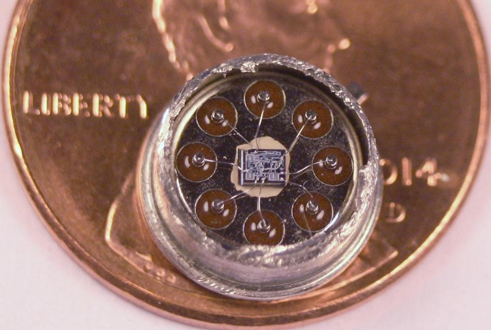 The 555 timer die inside a metal-can package, with a penny for comparison. Click this image (or any other) for a larger version.