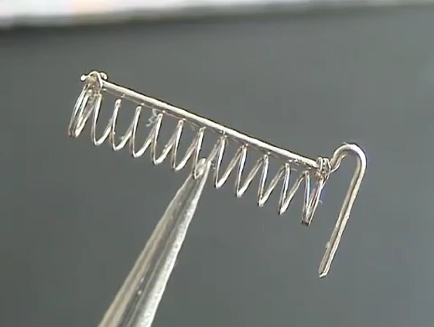 Фото 4.4. Устройство сетки. Никелевая спираль на траверсе закреплена сжатием и только на концах, коленце внизу траверсы обеспечивает удобство сварки при монтаже на ножку и некоторое регулирование положения сетки относительно нити катода