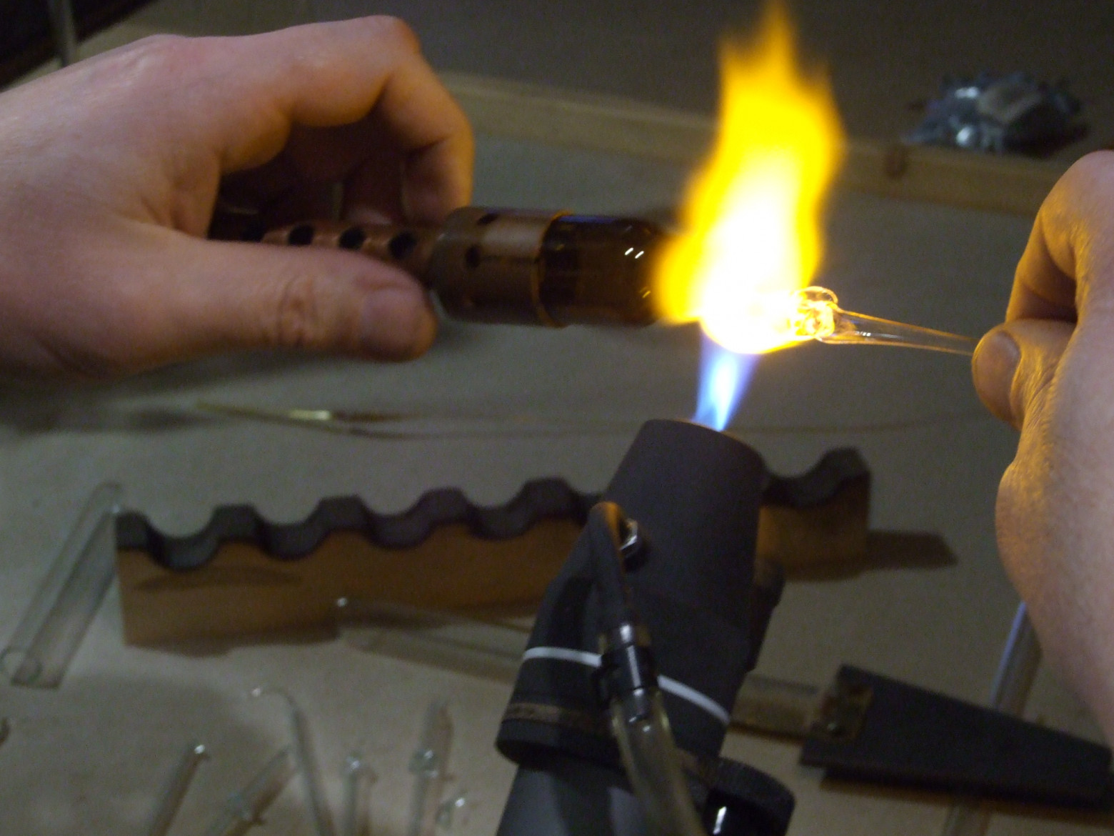 Фото 4.14. Контрольный — ещё одну нить из тех же образцов, но упрощённым способом: разогреем вытянутые остатки горлышка пузырька, сформуем из него лопаточку, налепим на неё крупную каплю сравниваемого стекла (на фото)