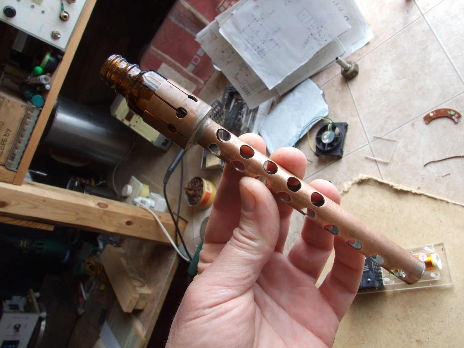 Фото 4.3. Отщипнуть образец размягчённого стекла от сравнительно толстой и короткой стекляшки крайне затруднительно без специальной державки. Такого рода вспомогательный инструмент стеклодувы старой школы мастерили по необходимости, не глядя и из подручных материалов — из стекла, металла, дерева, проволоки. Здесь удачно применил медную цангу с ручкой — часть старой ненужной конструкции