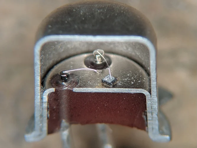 Поперечное сечение 2N2222 в металлическом корпусе TO-18, демонстрирующее соединительные провода между внешними выводами и кристаллом. Изображение использовано с разрешения TubeTimeUS через Wikimedia Commons (CC BY-SA 4.0)