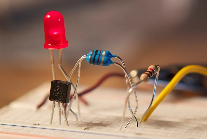 Транзистор 2N3904 (внизу слева) в корпусе TO-92 на макетной плате. Изображение предоставлено Autopilot через Wikimedia Commons (CC BY-SA 3.0)