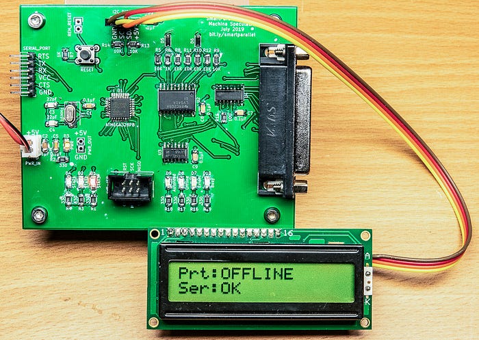 Close-up photograph of a printed circuit board to which is attached a small display that says: Prt: OFFLINE Ser: OK