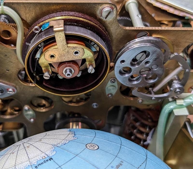 The potentiometer converts the orbital position into a voltage. To the right is the cam that produces the longitude display. Antarctica is visible on the globe.