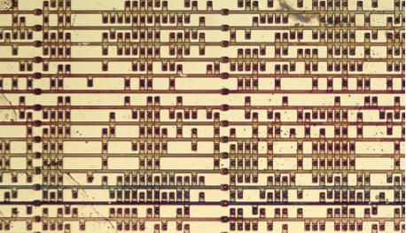 Фиг.27 микрофотография, фрагмент ПЗУ микрокода процессора Intel 8086 (отсюда). Видны транзисторы в местах, соответствующих единицам и пропуски на месте нулей. Некоторые транзисторы не соединены с дорожками, это артефакт травления химикатами в процессе приготовлений к съемке.  