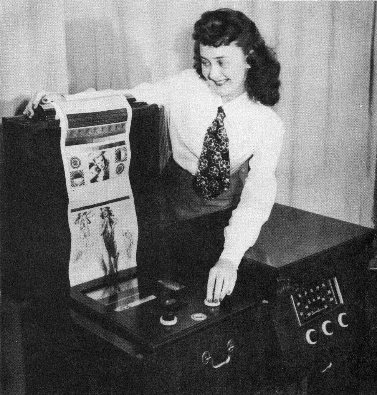 A woman demonstrates a faxpaper receiver made by the Stewart-Warner Corporation