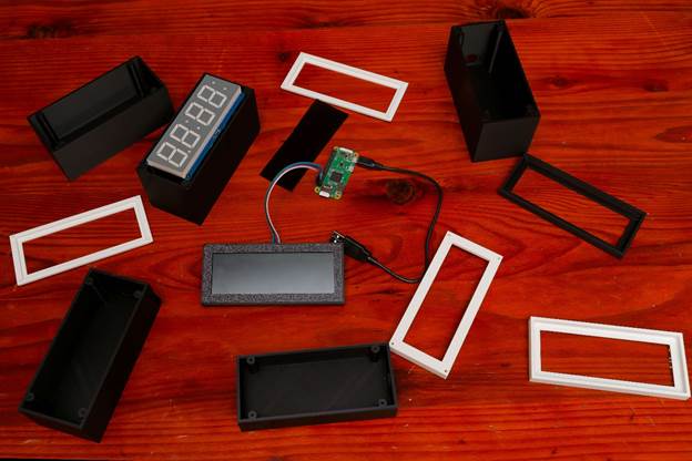 Photograph of a workspace with 3d printed clock components and some electronics
